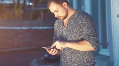 Genç adam akıllı telefonunu kullanıyor.