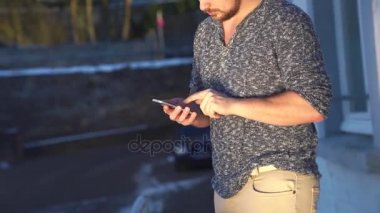 Genç adam akıllı telefonunu kullanıyor.