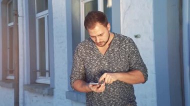 Genç adam akıllı telefonunu kullanıyor.