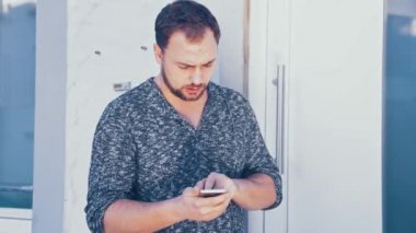 Genç adam akıllı telefonunu kullanıyor.