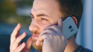Genç adam akıllı telefonunu kullanıyor.