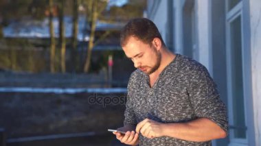 Genç adam akıllı telefonunu kullanıyor.