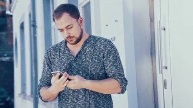 Genç adam akıllı telefonunu kullanıyor.