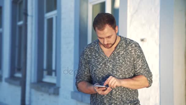 Молодой человек использует свой смартфон — стоковое видео