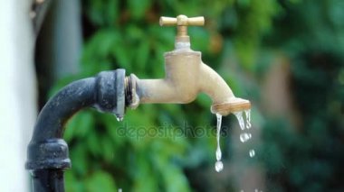 Süper ağır çekim çekim dış musluk suyu damlama ve splash bir sıcak yaz gününde