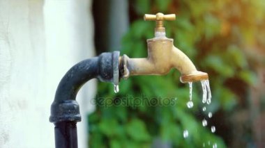 Süper ağır çekim çekim dış musluk suyu damlama ve splash bir sıcak yaz gününde