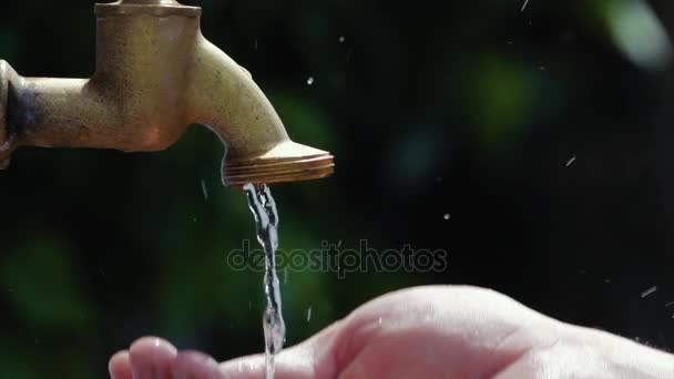 Toma en cámara súper lenta de agua del grifo exterior goteando y salpicando en un día caluroso de verano — Vídeos de Stock