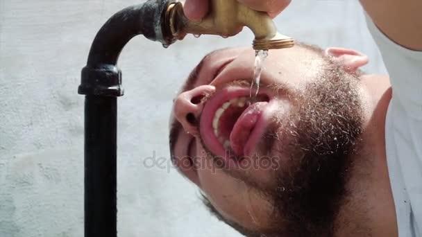 Toma en cámara súper lenta de agua del grifo exterior goteando y salpicando en un día caluroso de verano — Vídeo de stock