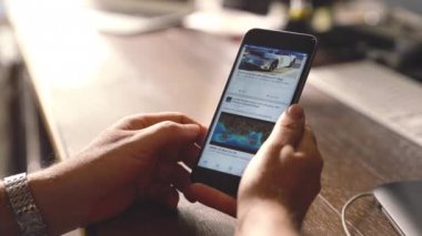 genç adam facebook app apple iPhone'da 6s artı ofiste kullanır 