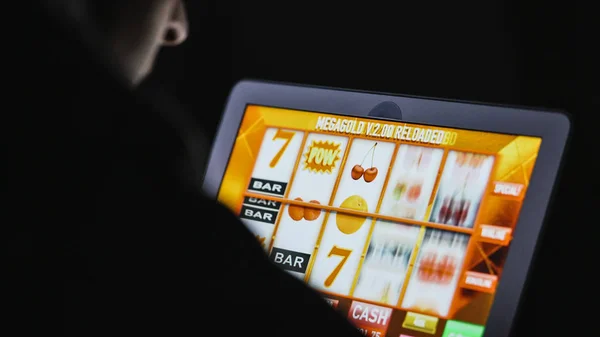 Man in front of online casino slot machine on laptop — Stock Photo, Image