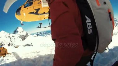 Alagna Valsesia'da, Piemont, İtalya - 28 Mart 2015: Snowboard actionsportlers Dağları nın üstündeki bir helikopterle düştü. Güneş mavi gökyüzünde parlıyor. Dağ silsilesi içinde geçmiş karla kaplı. Görüntüleri içeren markalar, logolar 