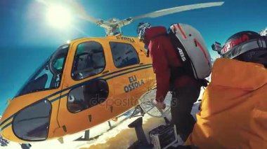 Alagna Valsesia'da, Piemont, İtalya - 28 Mart 2015: Snowboard actionsportlers Dağları nın üstündeki bir helikopterle düştü. Güneş mavi gökyüzünde parlıyor. Dağ silsilesi içinde geçmiş karla kaplı. Görüntüleri içeren markalar, logolar 