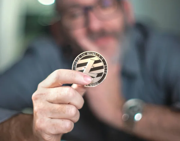 Litecoin cryptocurrency a kezében egy alkalmi üzletember — Stock Fotó