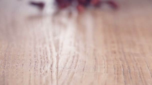 Goji ベリー本格的なスローモーション木製のテーブルの上に落ちての束 クローズ アップ — ストック動画