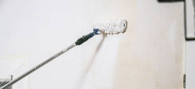 Oda beyaz renklerde boya için ressam rulo ve fırça ile çalışma kapatın. -Bunu kendinizi kazmak