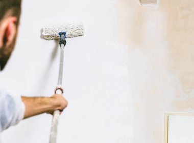 Oda beyaz renklerde boya için ressam rulo ve fırça ile çalışma kapatın. -Bunu kendinizi kazmak