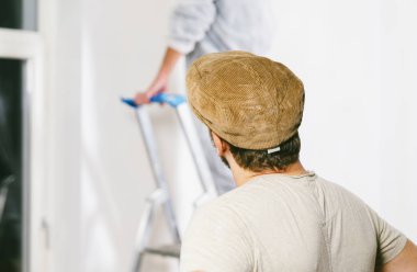 Oda beyaz renklerde boya için ressam rulo ve fırça ile çalışma kapatın. -Bunu kendinizi kazmak