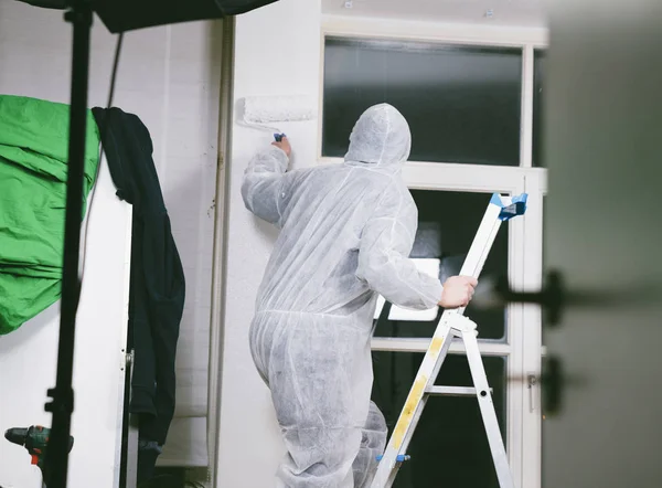 Close up of painter working with paint roller and brushes to paint the room in white colors. dig - do it yourself — Stock Image Close Painter Working Paint Roller Brushes Paint Room White Colors Royalty Free Stock Images