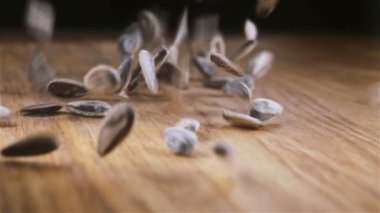 Bazı Ayçekirdeği ahşap masaya döküldü. Ağır çekimde kameraya doğru kayar.