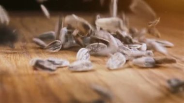 Bazı Ayçekirdeği ahşap masaya döküldü. Ağır çekimde kameraya doğru kayar.