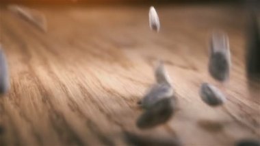 Bazı Ayçekirdeği ahşap masaya döküldü. Ağır çekimde kameraya doğru kayar.