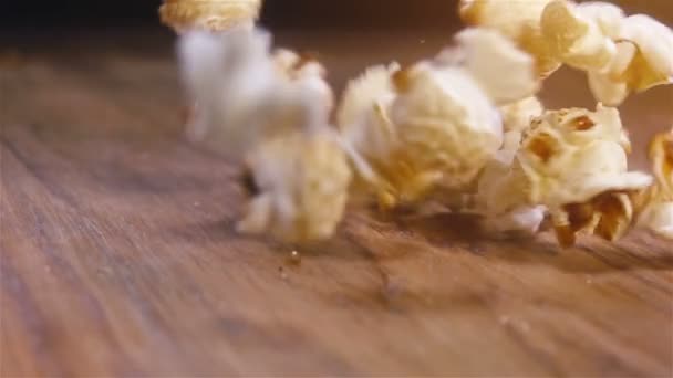 新鲜蓬松的爆米花落在地道的木桌上 超慢动作镜头 — 图库视频影像