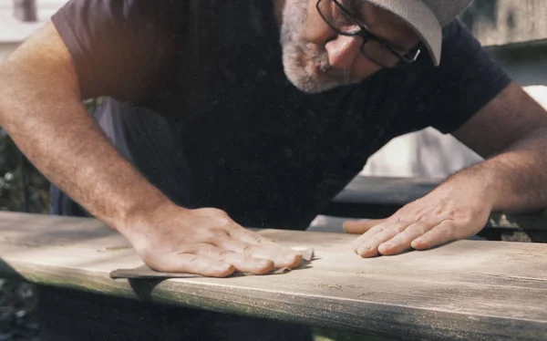 Людина шліфує деревину на відкритому повітрі шліфування меблів — стокове фото
