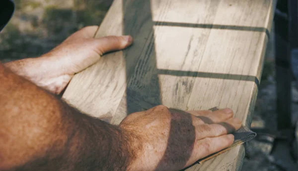 Ο άνθρωπος λείανση του ξύλου σε εξωτερικούς χώρους - λείανση έπιπλα — Φωτογραφία Αρχείου