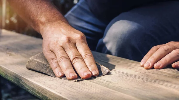 Mann schleift Holz im Freien - Möbel schleifen — Stockfoto