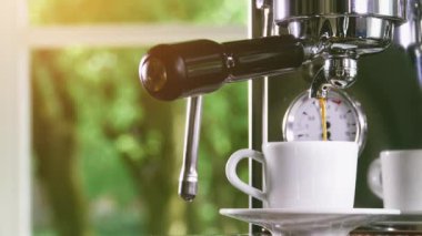 Klasik kahve makinesinden küçük beyaz fincan içine dökme espresso. Yakın çekim Shot.