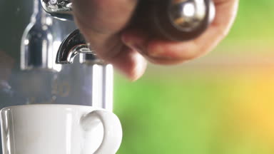 Klasik kahve makinesinden küçük beyaz fincan içine dökme espresso. Yakın çekim Shot.