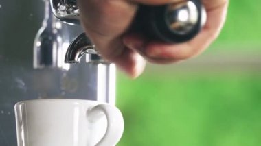 Klasik kahve makinesinden küçük beyaz fincan içine dökme espresso. Yakın çekim Shot.