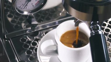 Klasik kahve makinesinden küçük beyaz fincan içine dökme espresso. Yakın çekim Shot.
