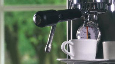 Klasik kahve makinesinden küçük beyaz fincan içine dökme espresso. Yakın çekim Shot.