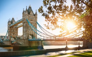 London Tower bridge adlı bir gün güneşli yaz - gündoğumu parlayan güneşe karşı açık mavi gökyüzü vurdu
