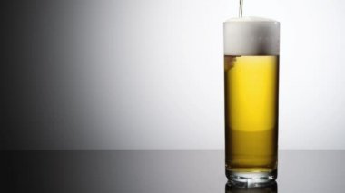 Biranın bira bardağına aktığı çok yavaş çekimde yüksek hız kamerası ile çekilmiş.