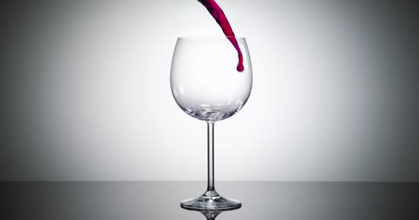 超スローモーション超高速カメラで撮影された大きなボルドーワイングラスに流れる赤ワインの高速ショット — ストック動画