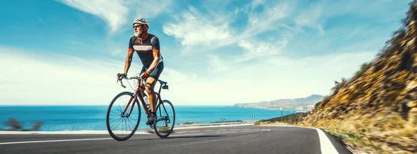 Mature Adult on a racing bike climbing the hill — Stock Photo, Image