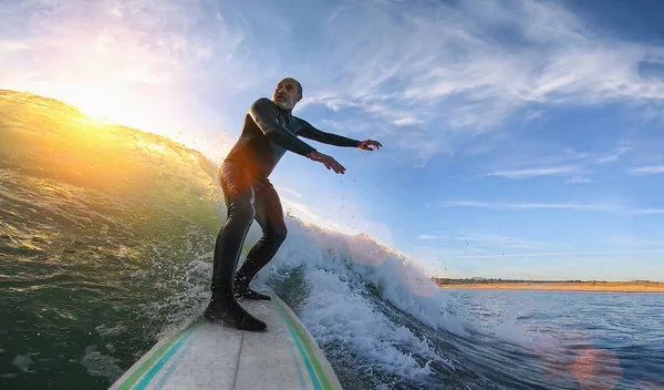 Mature senior adult surfing on a big wave in the ocean — 스톡 사진