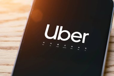 Uber sürücüsü akıllı telefonu arabada tutuyor. Uber bir Amerikan şirketidir.