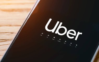 Uber sürücüsü akıllı telefonu arabada tutuyor. Uber bir Amerikan şirketi.