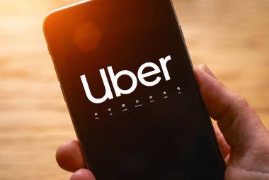Uber sürücüsü akıllı telefonu arabada tutuyor. Uber bir Amerikan şirketi.