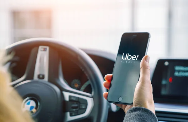 Uber sürücüsü akıllı telefonu arabada tutuyor. Uber bir Amerikan şirketi. — Stok fotoğraf