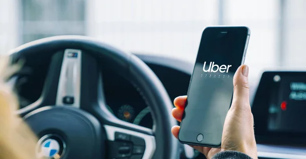 Uber driver holding smartphone in car. Uber is an American compa — Stock Photo, Image