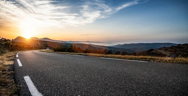 Camino largo vacío de la montaña al horizonte en un día soleado del verano en —  Fotos de Stock