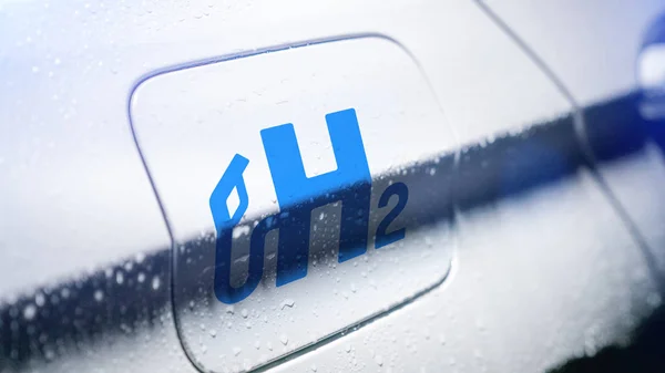 Auto met waterstoflogo op vuldop. h2 verbrandingsmotor voor e — Stockfoto