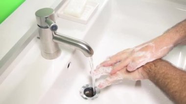 Virüs enfeksiyonunu önlemek için ellerini yıkayan bir adam.