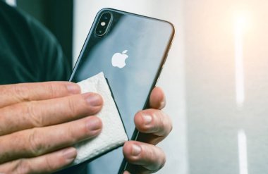 Elma temizleme iPhone ekranı temiz akıllı telefon için mendilleri dezenfekte eden kişi. COVID-19 Coronavirüs Salgın Önleme Konsepti.