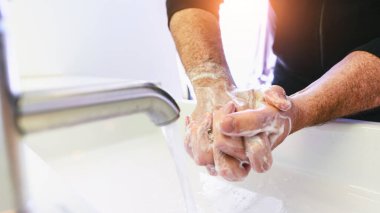 Virüs enfeksiyonunu önlemek için ellerini yıkayan adam ve temiz eller - Corona covid-19 konsepti...