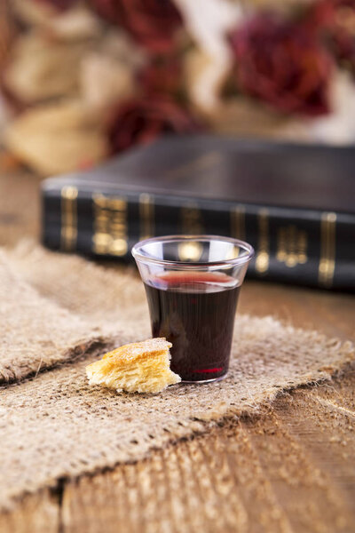 Taking Communion. Cup of glass with red wine and bread.